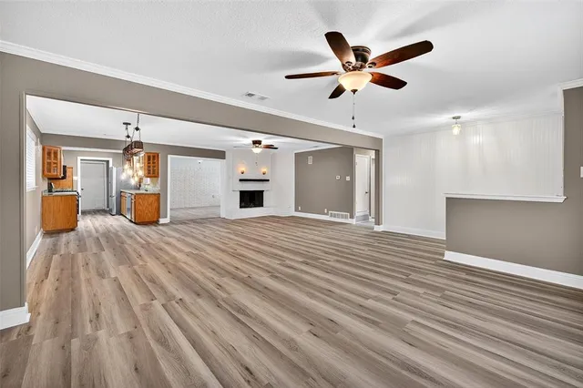 a view of empty room with wooden floor and ceiling fan