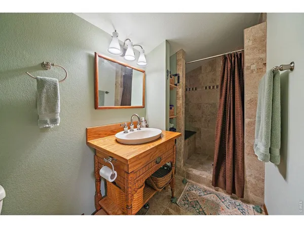 a bathroom with a sink a mirror a vanity and a shower