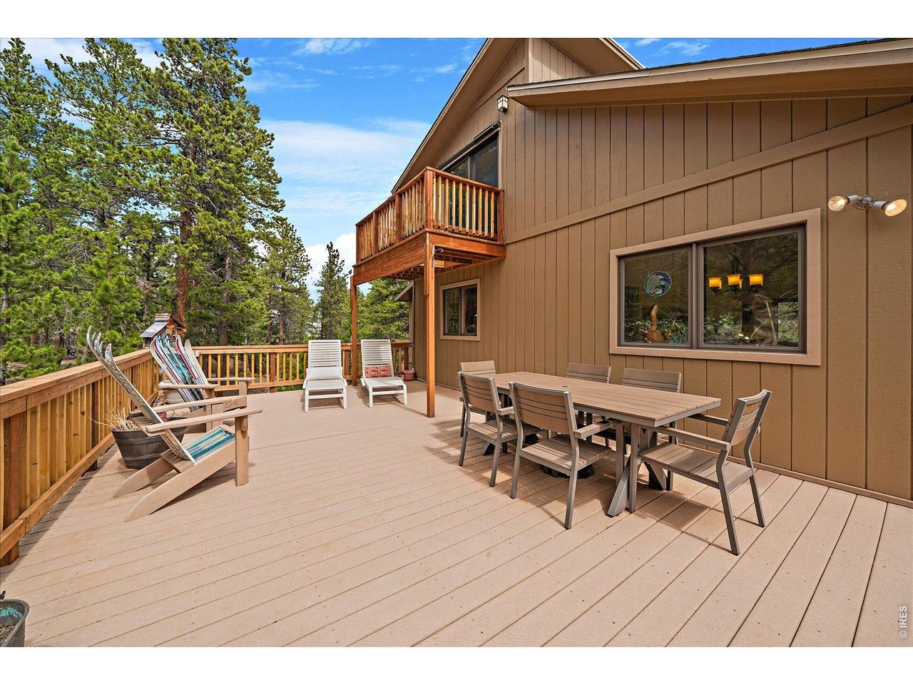 902 Rock Lake Road Ward, CO 80481 - Photo 22 of 32 a view of a roof deck with table and chairs floor to ceiling window with wooden floor