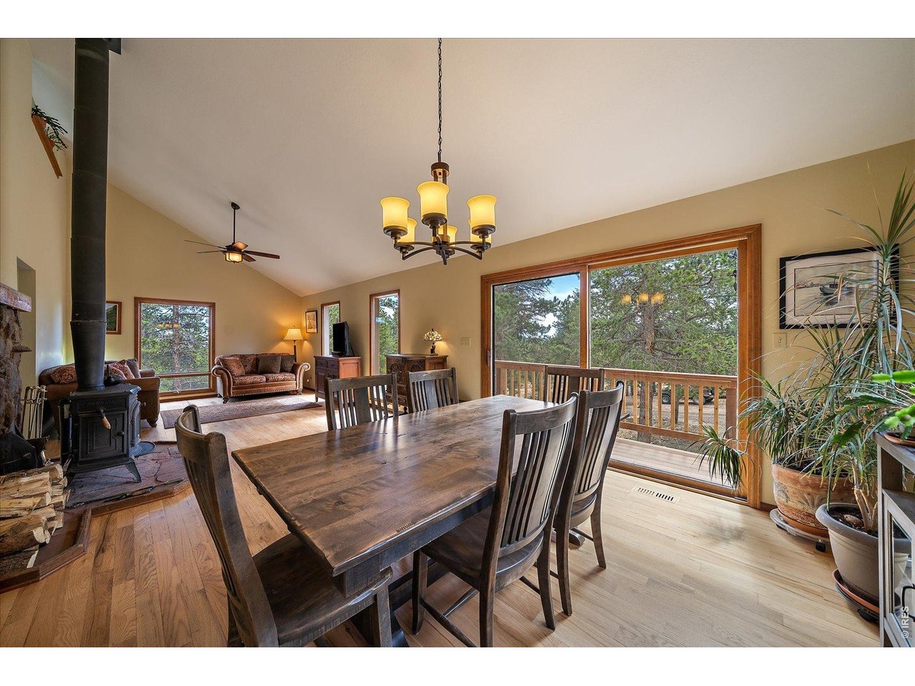 902 Rock Lake Road Ward, CO 80481 - Photo 4 of 32 a dining room with wooden floor a chandelier a wooden table and chairs