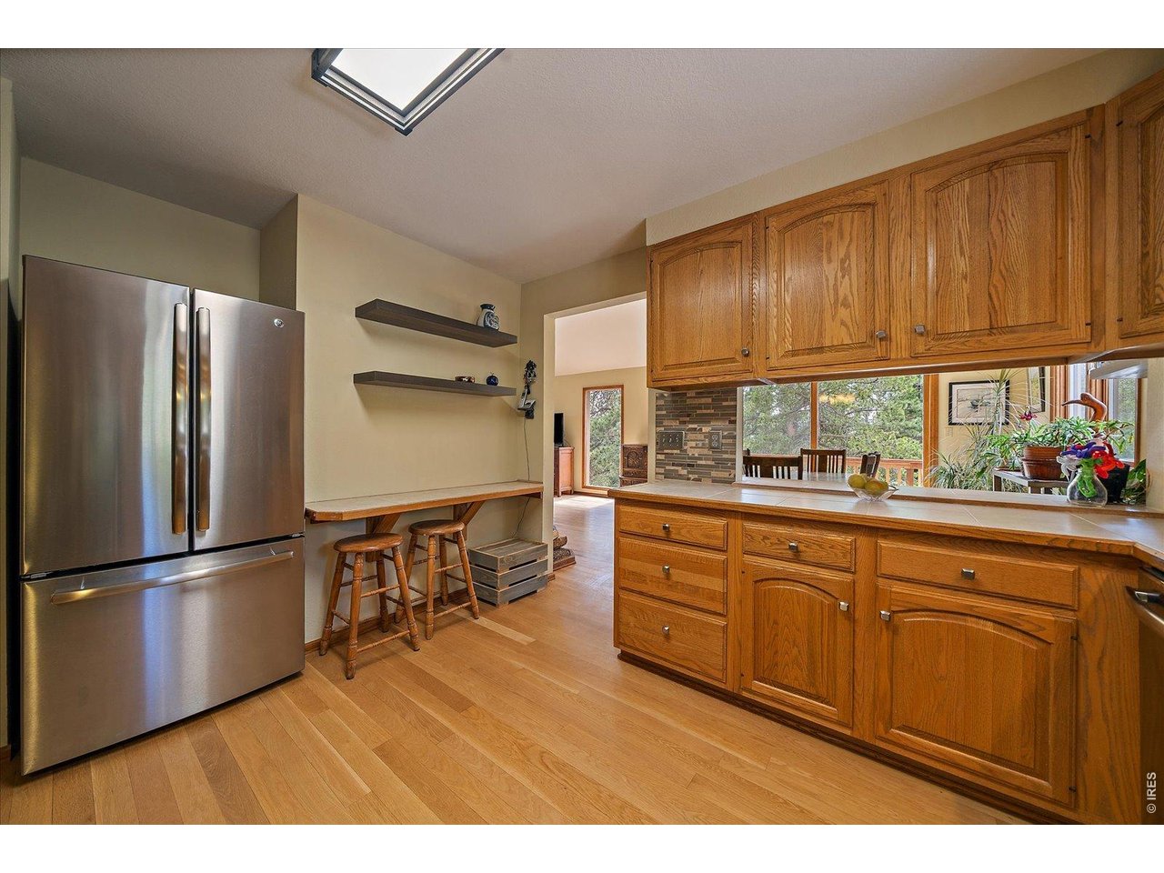 902 Rock Lake Road Ward, CO 80481 - Photo 10 of 32 a kitchen with stainless steel appliances granite countertop a refrigerator a sink dishwasher and wooden cabinets with wooden floor