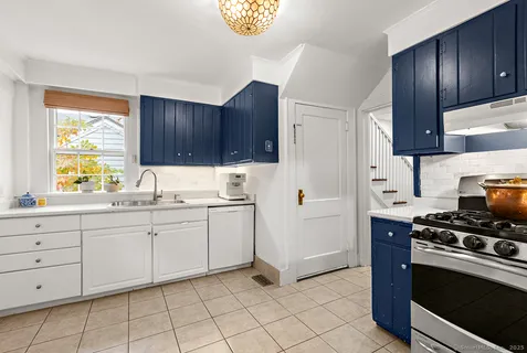 a kitchen with granite countertop white cabinets and white appliances