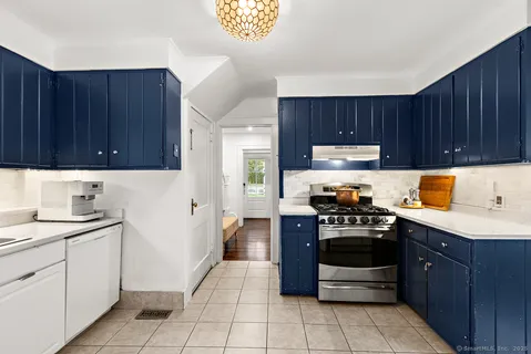 a kitchen with a stove sink and cabinets