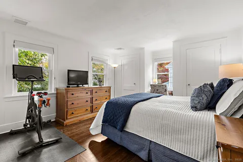 a bedroom with a bed and a flat tv screen on dresser