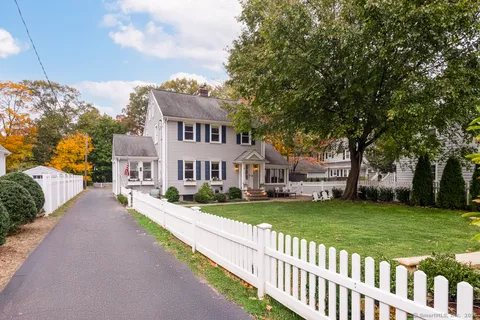 a view of a house with a big yard and large trees