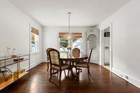 a dining room with furniture a chandelier and wooden floor
