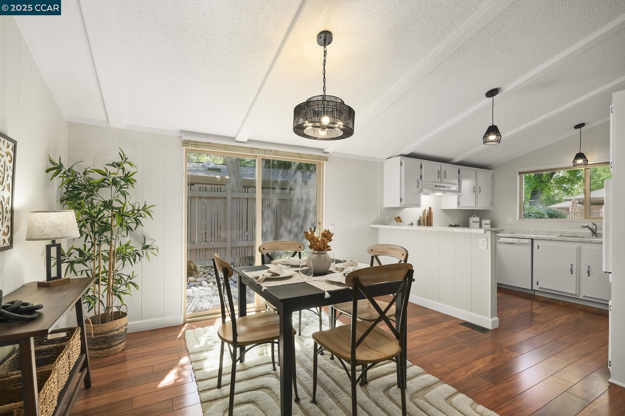 1201 Monument Boulevard, Unit 36 Concord, CA 94520 - Photo 1 of 1 a dining room with wooden floor a chandelier a wooden table and chairs