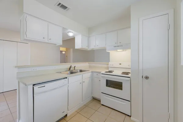 a kitchen with white cabinets and white appliances