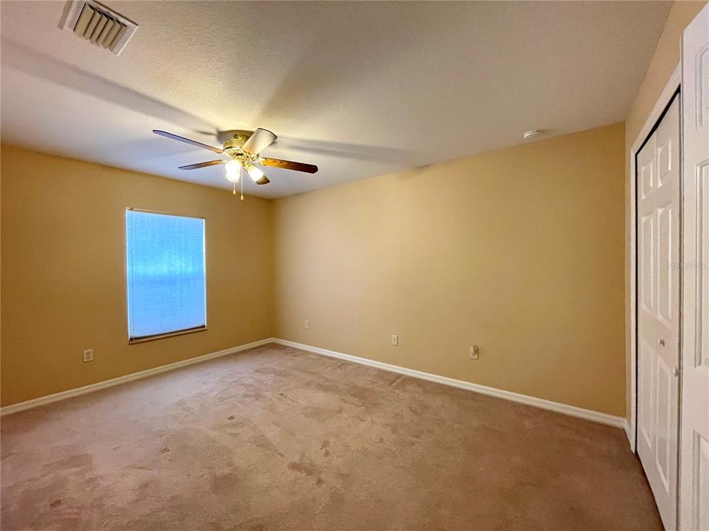 16026 Southwest 14th Avenue Road Ocala, FL 34473 - Photo 55 of 79 an empty room with a chandelier fan and a window