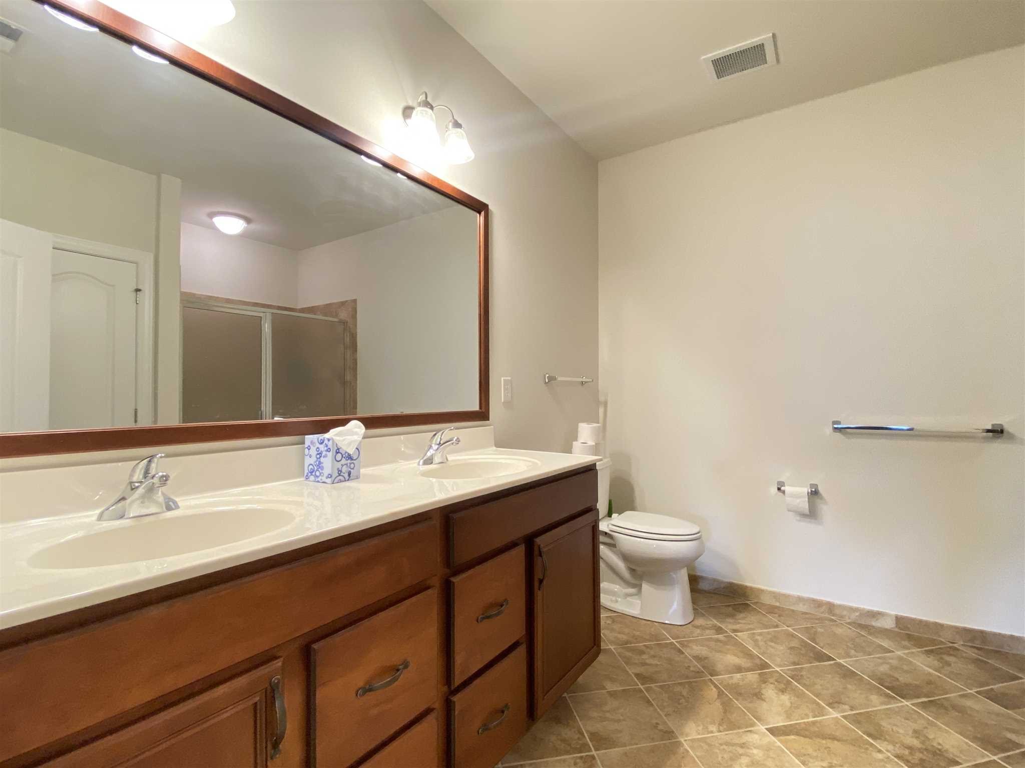643 Regency Drive Fishkill, NY 12524 - Photo 20 of 37 a bathroom with a double vanity sink a toilet and a mirror