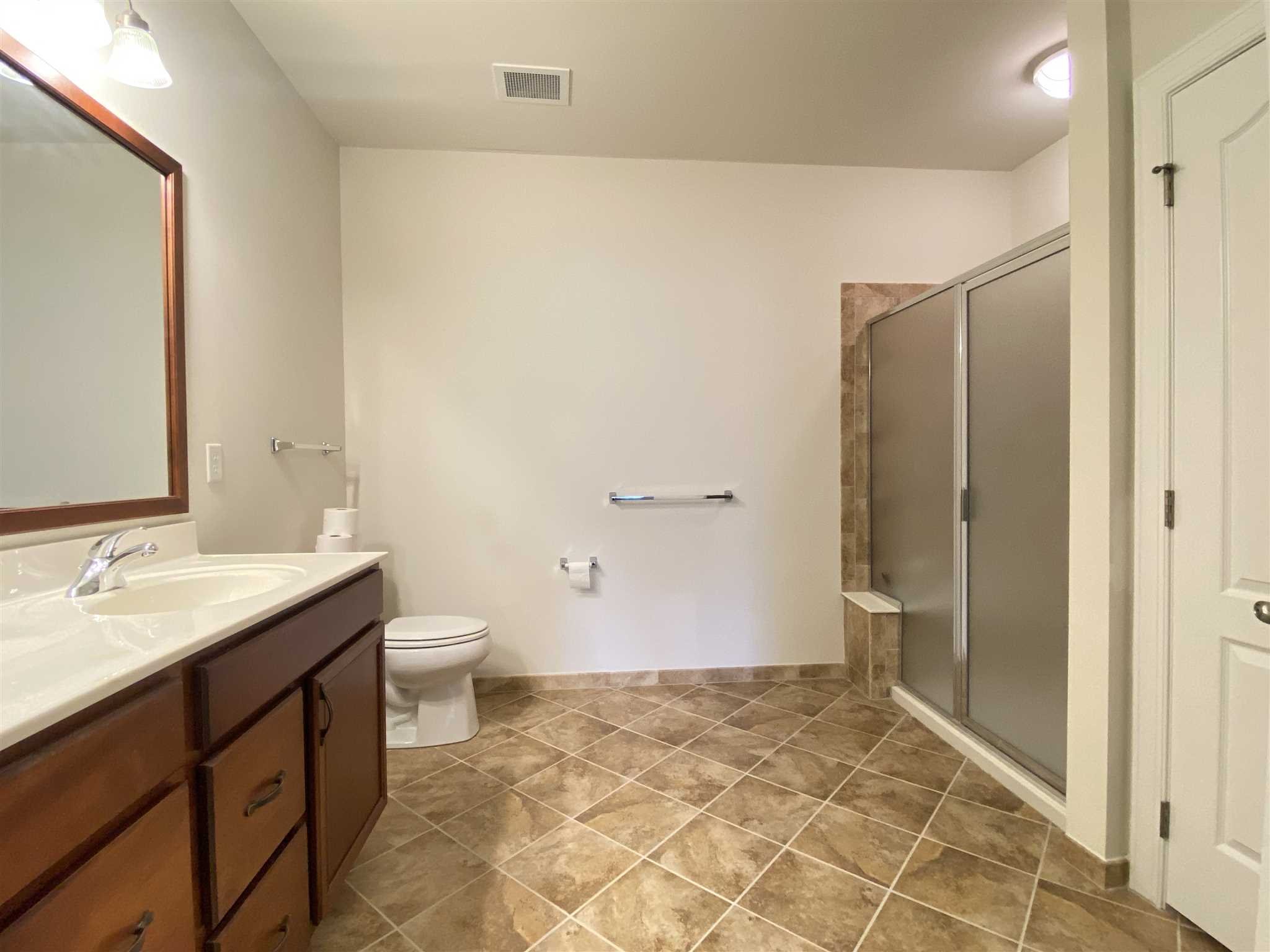 643 Regency Drive Fishkill, NY 12524 - Photo 21 of 37 a bathroom with a granite countertop sink a toilet and a mirror