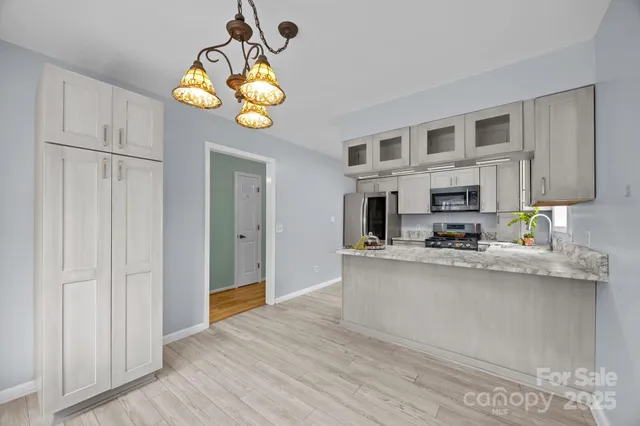 a view of a kitchen with stainless steel appliances granite countertop a stove and cabinets