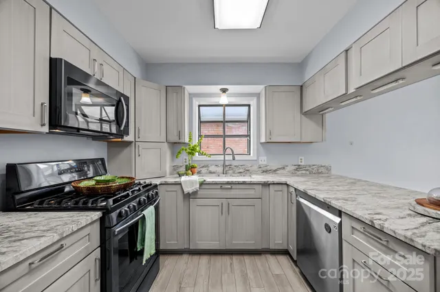 a kitchen with stainless steel appliances granite countertop a sink stove top oven and cabinets