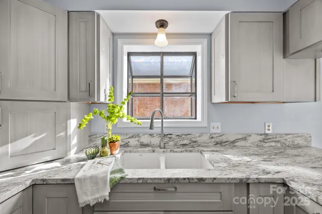 a view of a kitchen sink microwave and cabinets