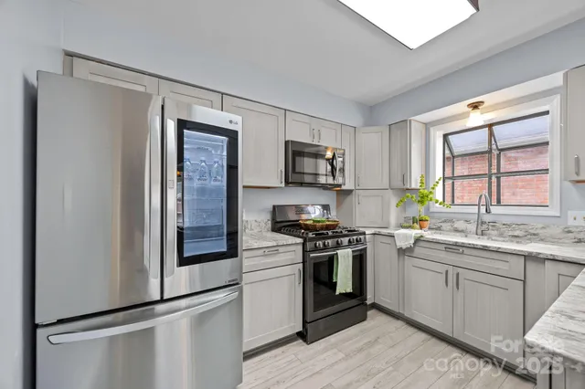 a kitchen with stainless steel appliances granite countertop a stove a sink and a refrigerator