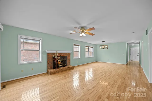 a view of an empty room with a window and fireplace