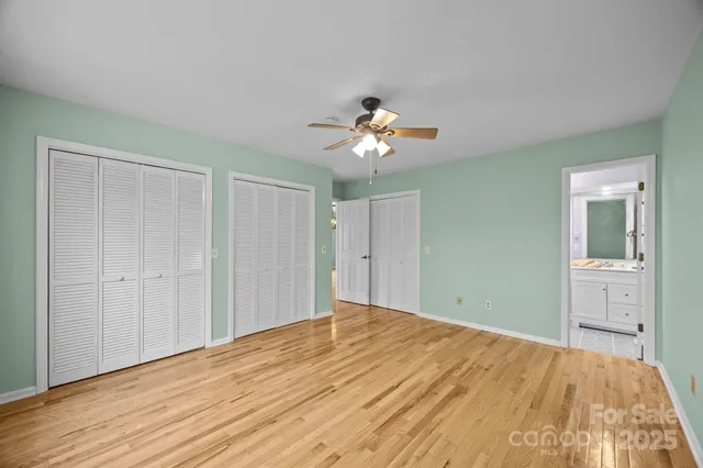 a view of a room with a chandelier fan and wooden floor