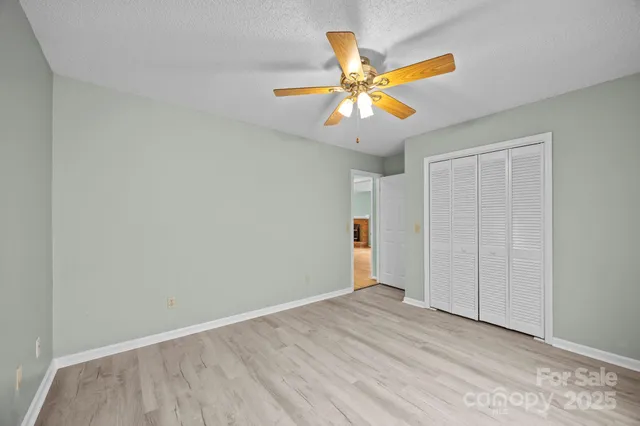 an empty room with a window and a fan