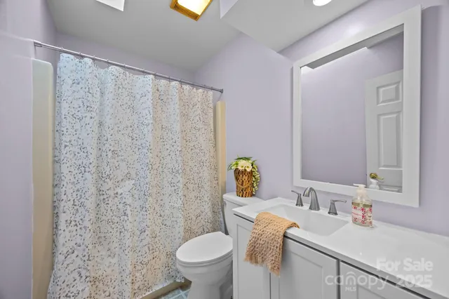 a bathroom with a granite countertop sink a toilet and a mirror