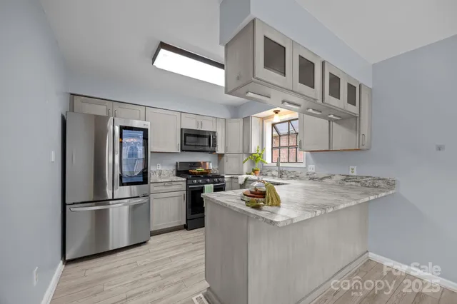 a kitchen with stainless steel appliances granite countertop a refrigerator a stove a sink dishwasher and a refrigerator