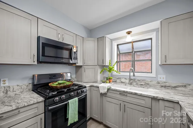 a kitchen with stainless steel appliances granite countertop a sink a stove and microwave