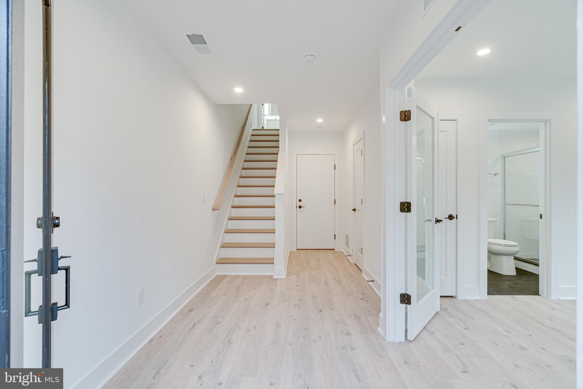 2070 Tysons Ridgeline Road Falls Church, VA 22043 - Photo 6 of 57 a view of a hallway with wooden floor and a bathroom