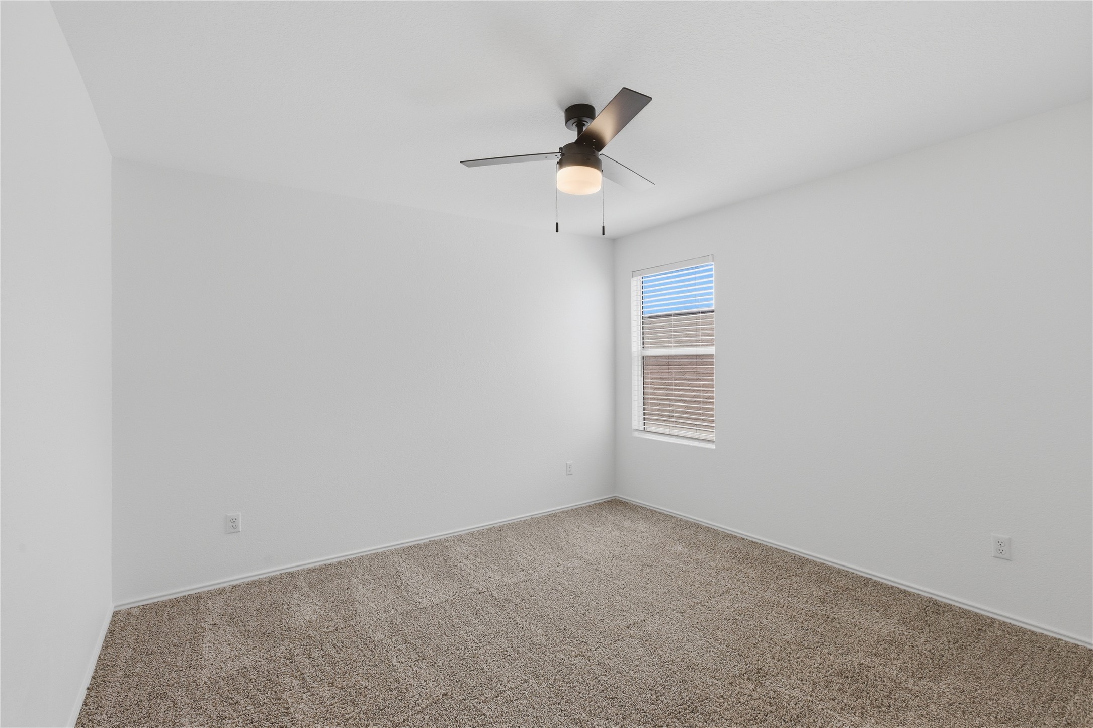 116 Night Riders Way Jarrell, TX 76537 - Photo 28 of 40 Neutral-toned carpeting in a room featuring a window with horizontal blinds and a ceiling fan with integrated lighting