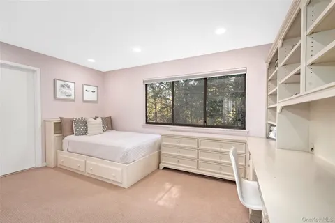 a bathroom with a toilet a sink a mirror and a window