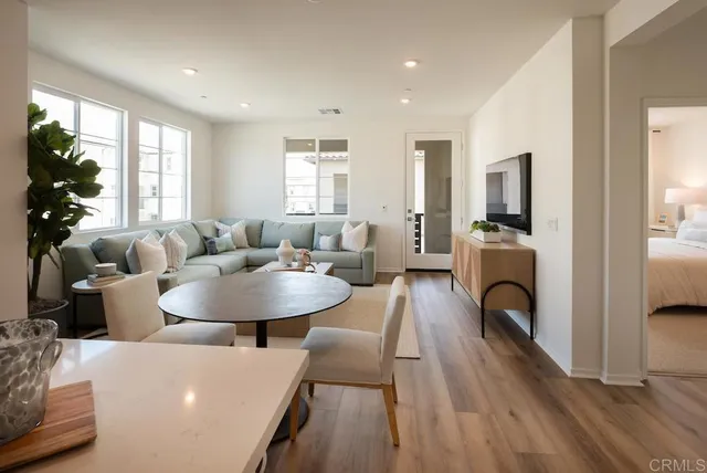 a living room with furniture a fireplace a flat screen tv and a large window