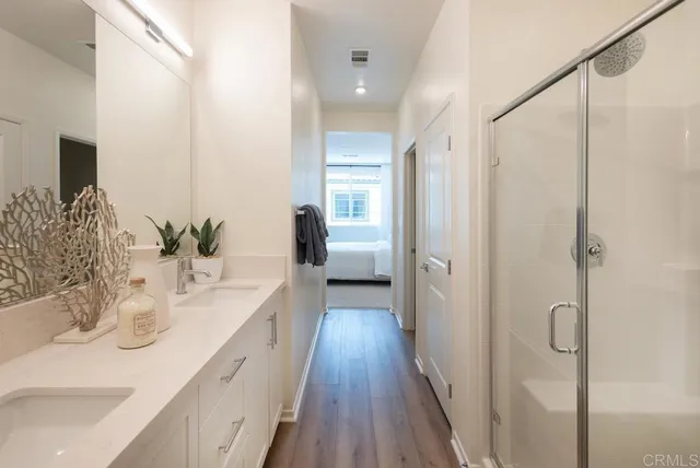 a bathroom with a double vanity sink a mirror and shower