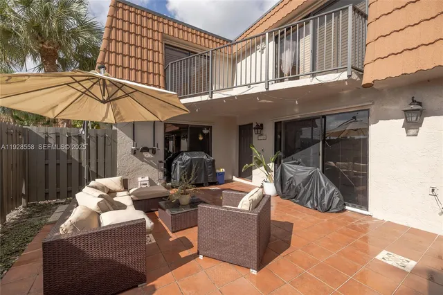 a view of a patio with a table and chairs under an umbrella