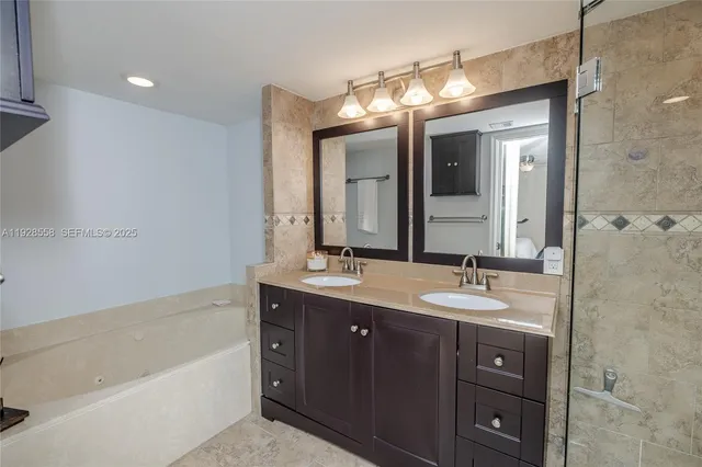 a bathroom with a double vanity sink mirror and bathtub