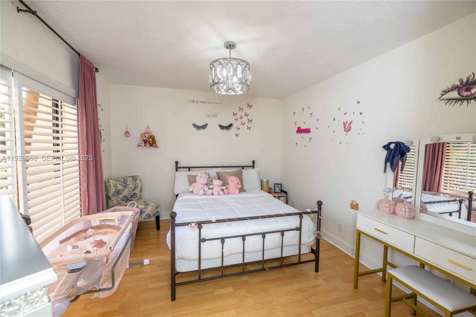 11006 North Harmony Lake Circle Davie, FL 33324 - Photo 22 of 46 a bedroom with a bed and a chandelier