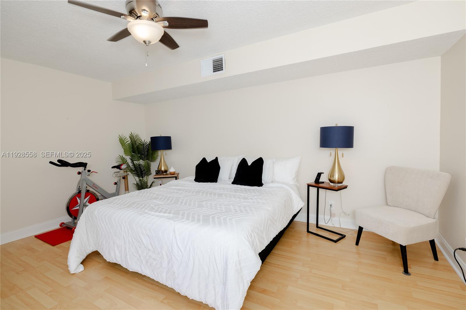 11006 North Harmony Lake Circle Davie, FL 33324 - Photo 27 of 46 a bedroom with a bed a chair and a potted plant on the dresser