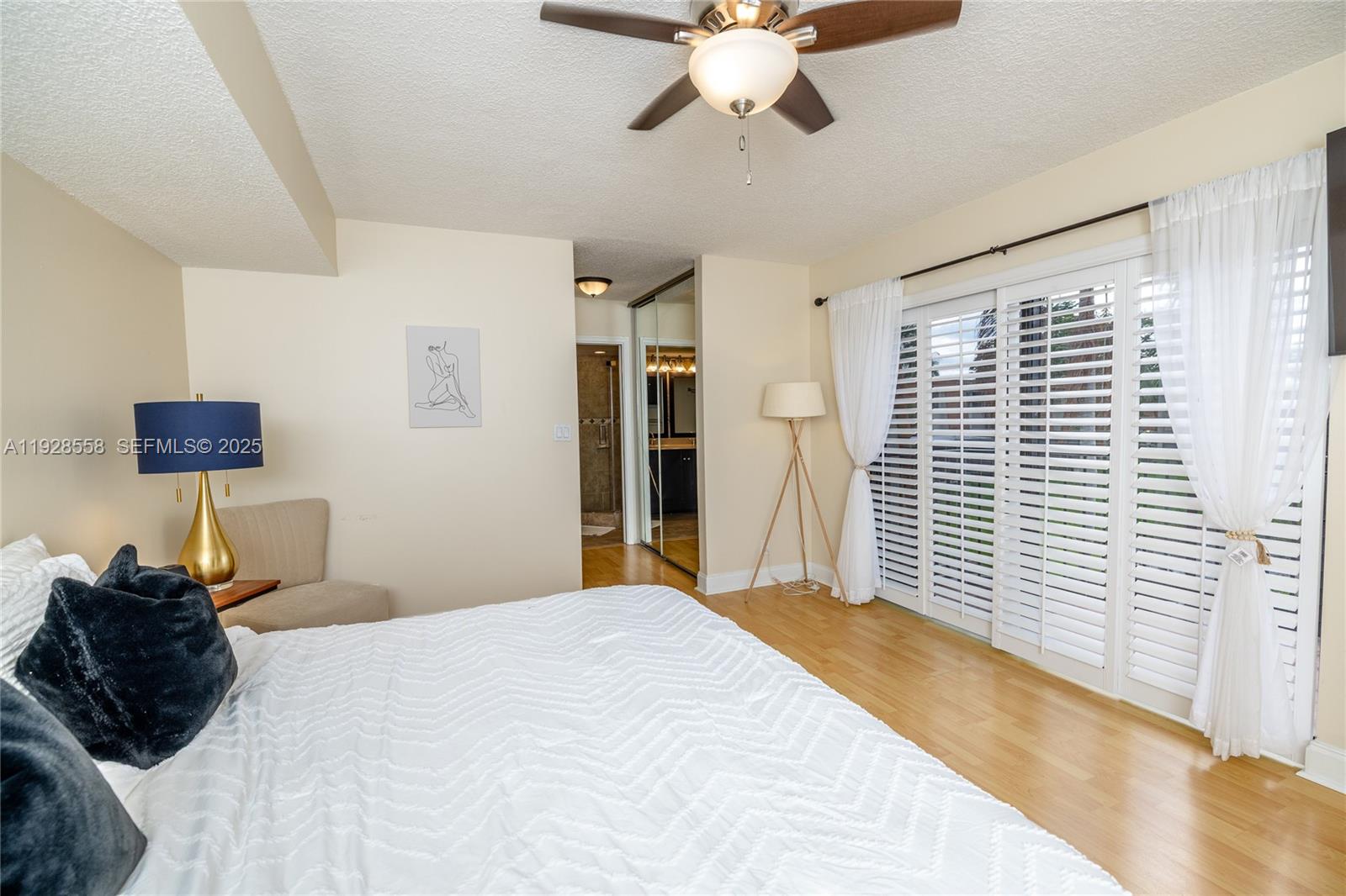 11006 North Harmony Lake Circle Davie, FL 33324 - Photo 28 of 46 a bedroom with a bed window and a chandelier