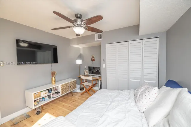 a bedroom with a bed and a flat tv screen on dresser