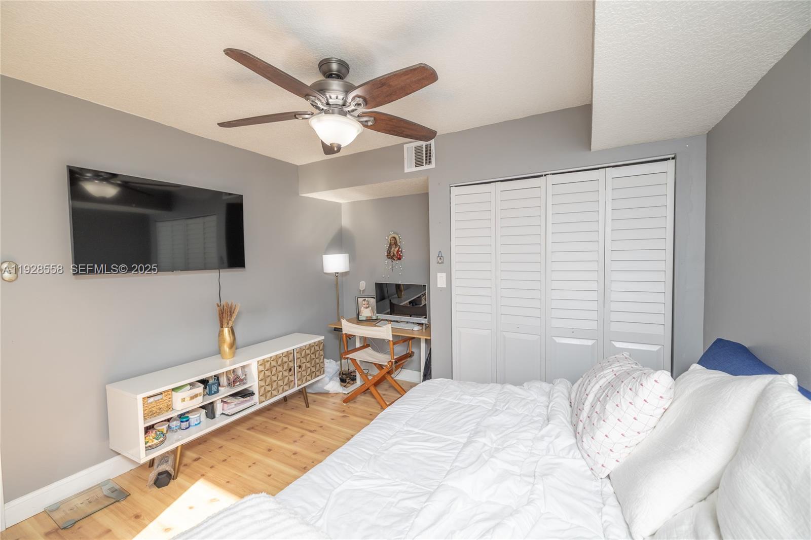11006 North Harmony Lake Circle Davie, FL 33324 - Photo 30 of 46 a bedroom with a bed and a flat tv screen on dresser