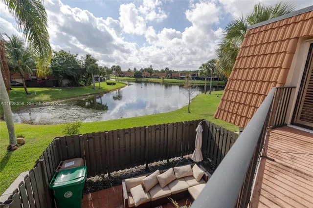 a view of a roof deck with couches and wooden fence