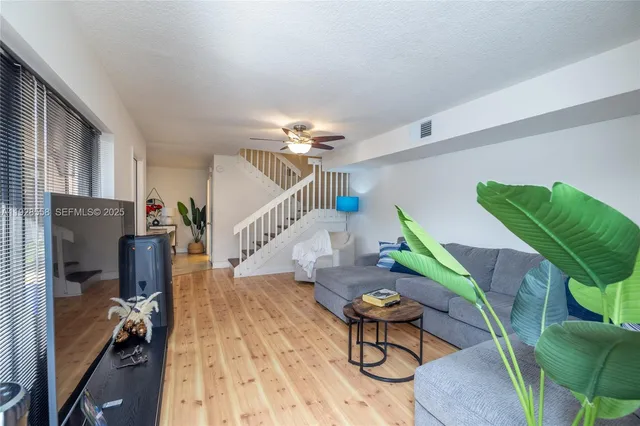 a living room with furniture and a wooden floor