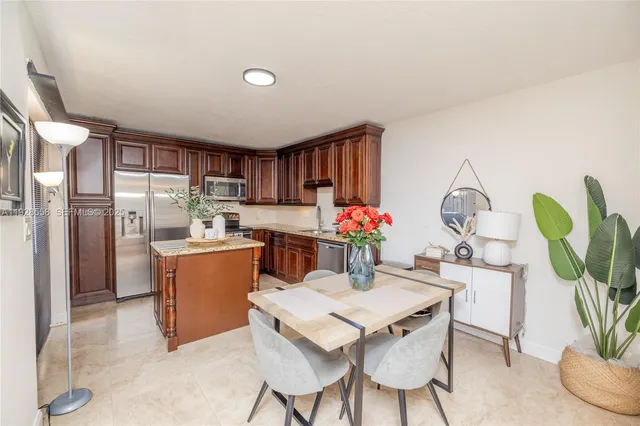 a dining room filled chandelier and kitchen view