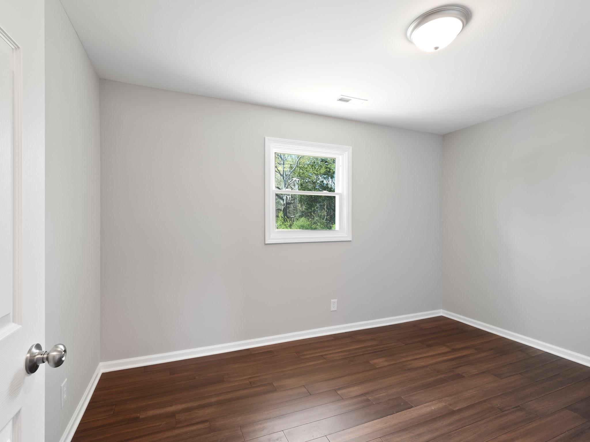 1813 Timber Ln Drive Monroe, NC 28110 - Photo 22 of 35 wooden floor in an empty room with a window