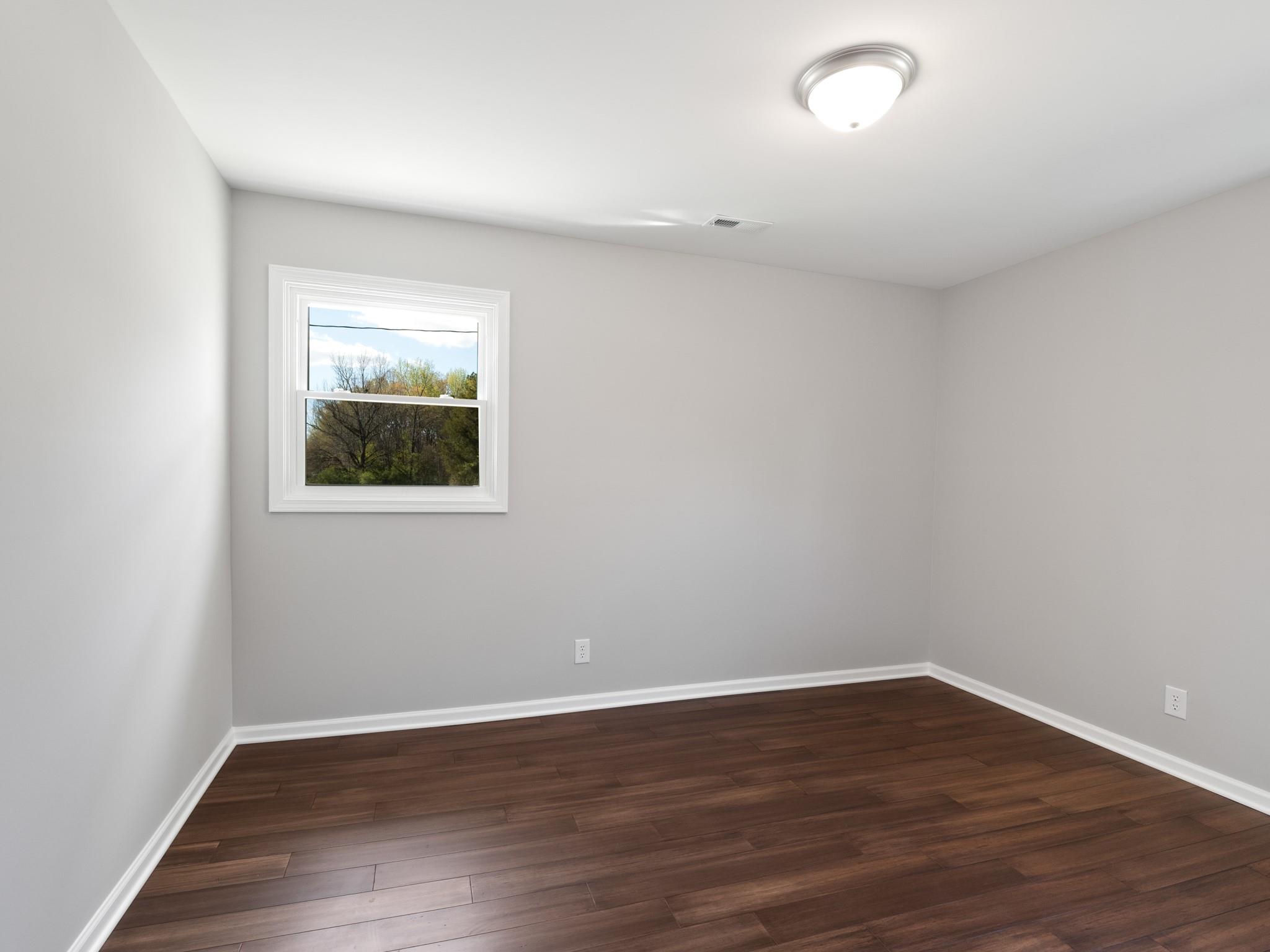 1813 Timber Ln Drive Monroe, NC 28110 - Photo 23 of 35 a view of an empty room with wooden floor and a window