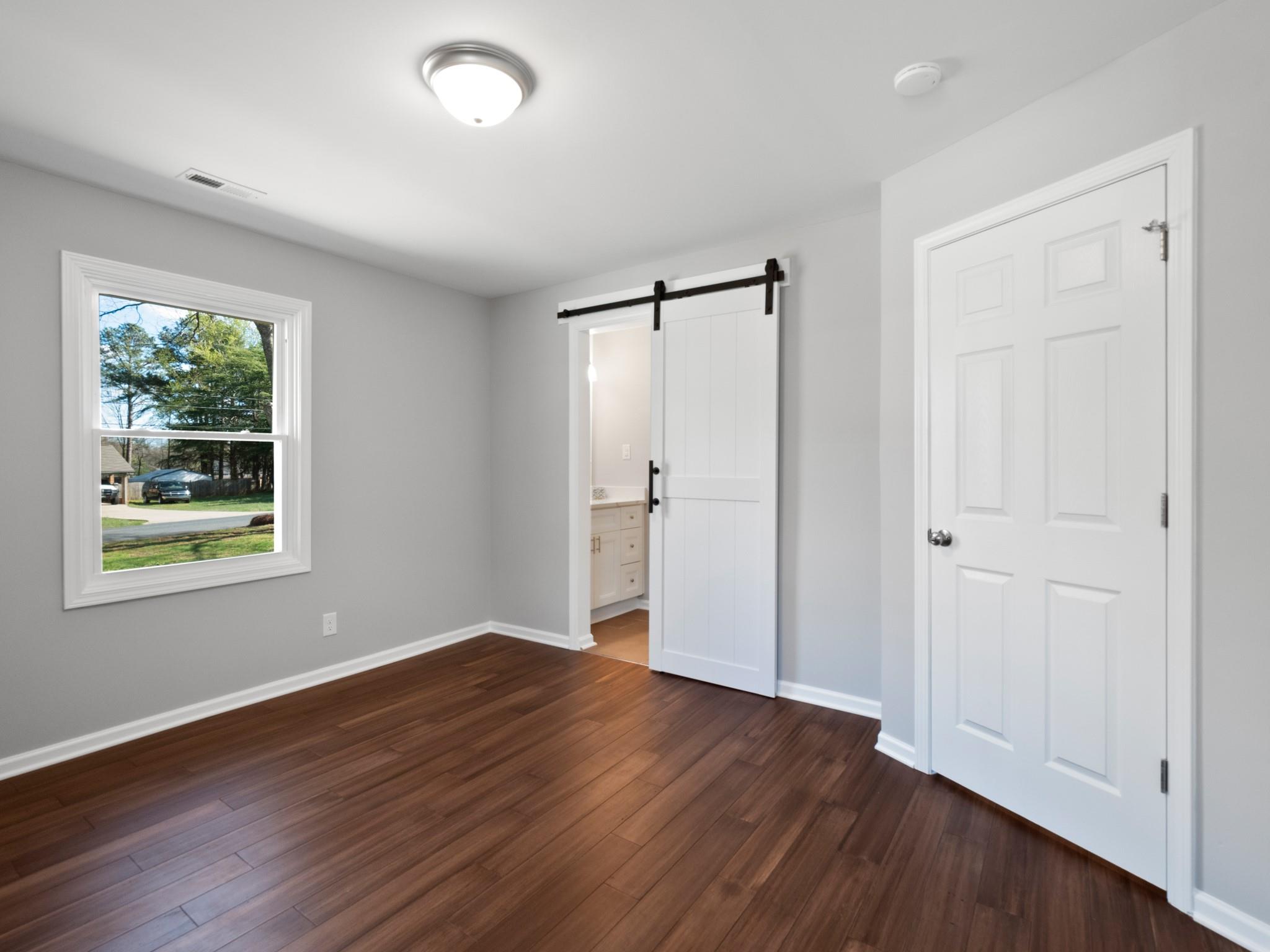 1813 Timber Ln Drive Monroe, NC 28110 - Photo 26 of 35 an empty room with wooden floor and windows