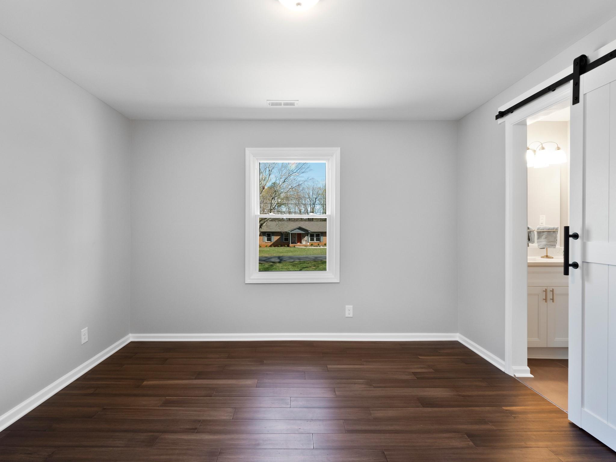 1813 Timber Ln Drive Monroe, NC 28110 - Photo 27 of 35 a view of an empty room with wooden floor and a window