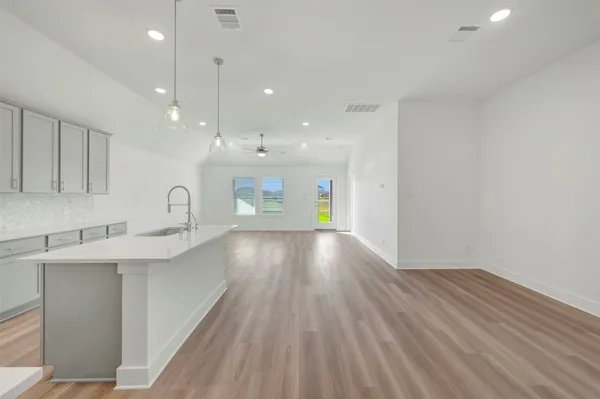 a kitchen with a sink and wooden floor