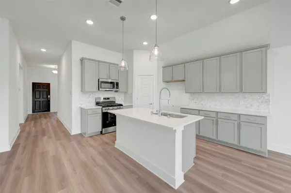 a kitchen with a sink a microwave and cabinets