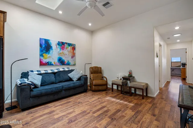 a view of a patio with table and chairs and couches with wooden floor and fence