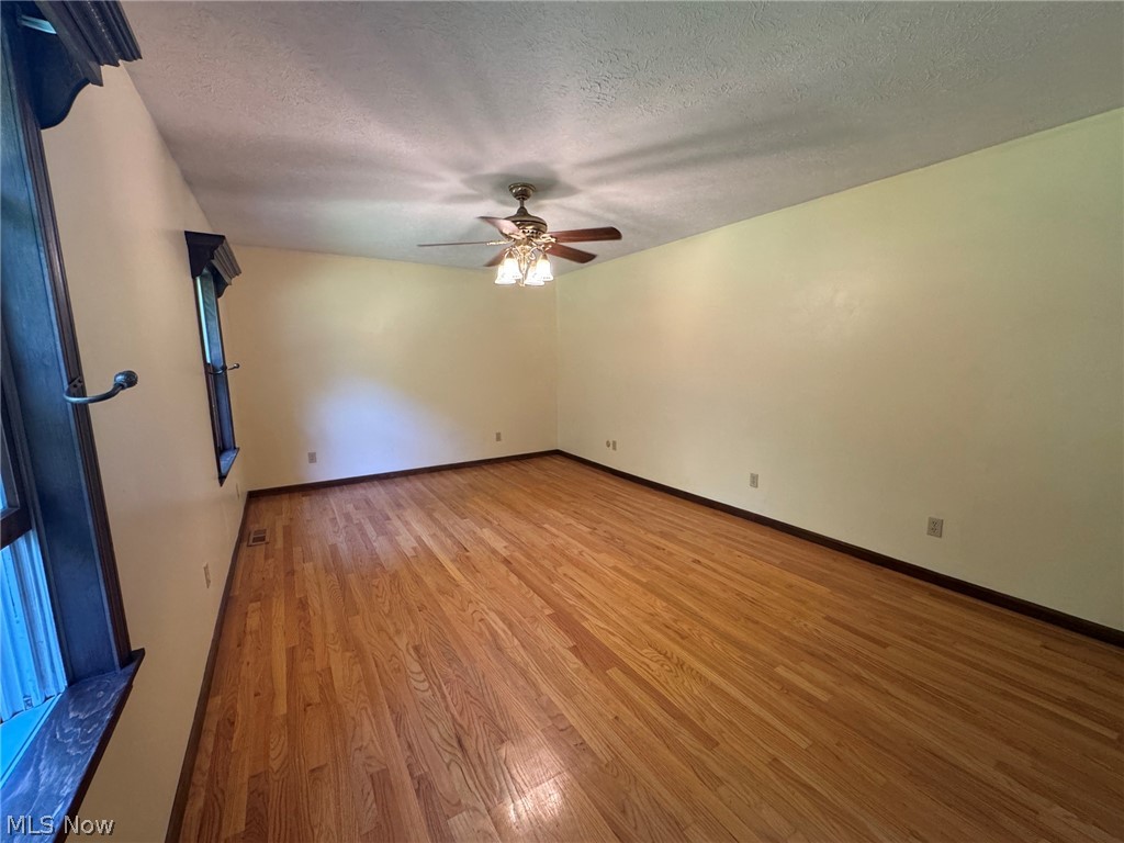 8201 Orchard Road Painesville, OH 44077 - Photo 23 of 45 Spacious interior room featuring hardwood flooring, light-colored walls, and a ceiling fan with integrated lighting