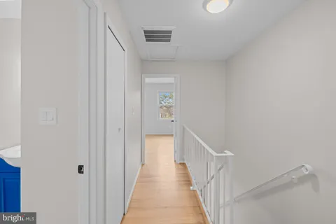 a view of a hallway with a white walls and stairs