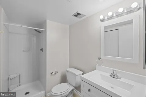 a bathroom with a sink a toilet and shower